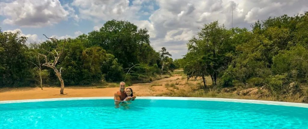Casal se abraçando em piscina de hotel Kapama na África do Sul 