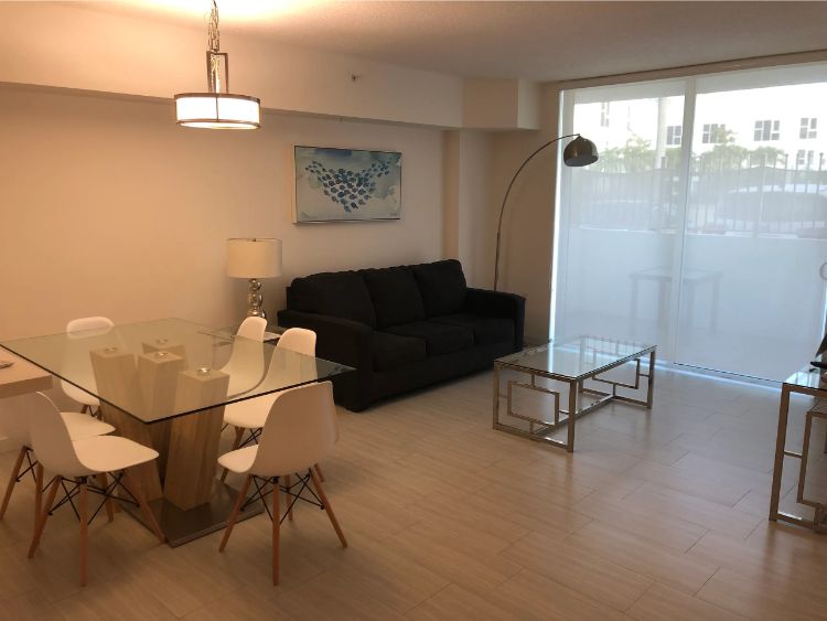 Sala com sofá, mesa, cadeiras e abajur