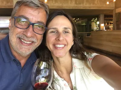 Casal sorrindo com taça de vinho na mão em vinícola Tokara em Stellenbosch