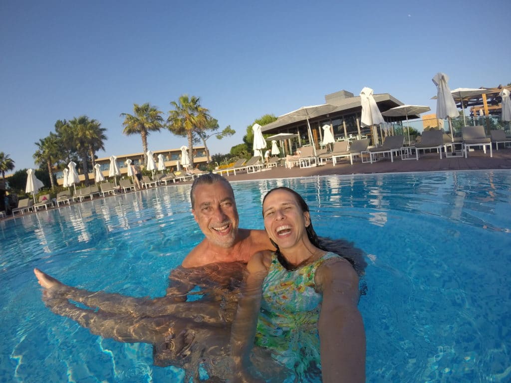 Homem carregando mulher dentro de piscina de hotel no Algarve