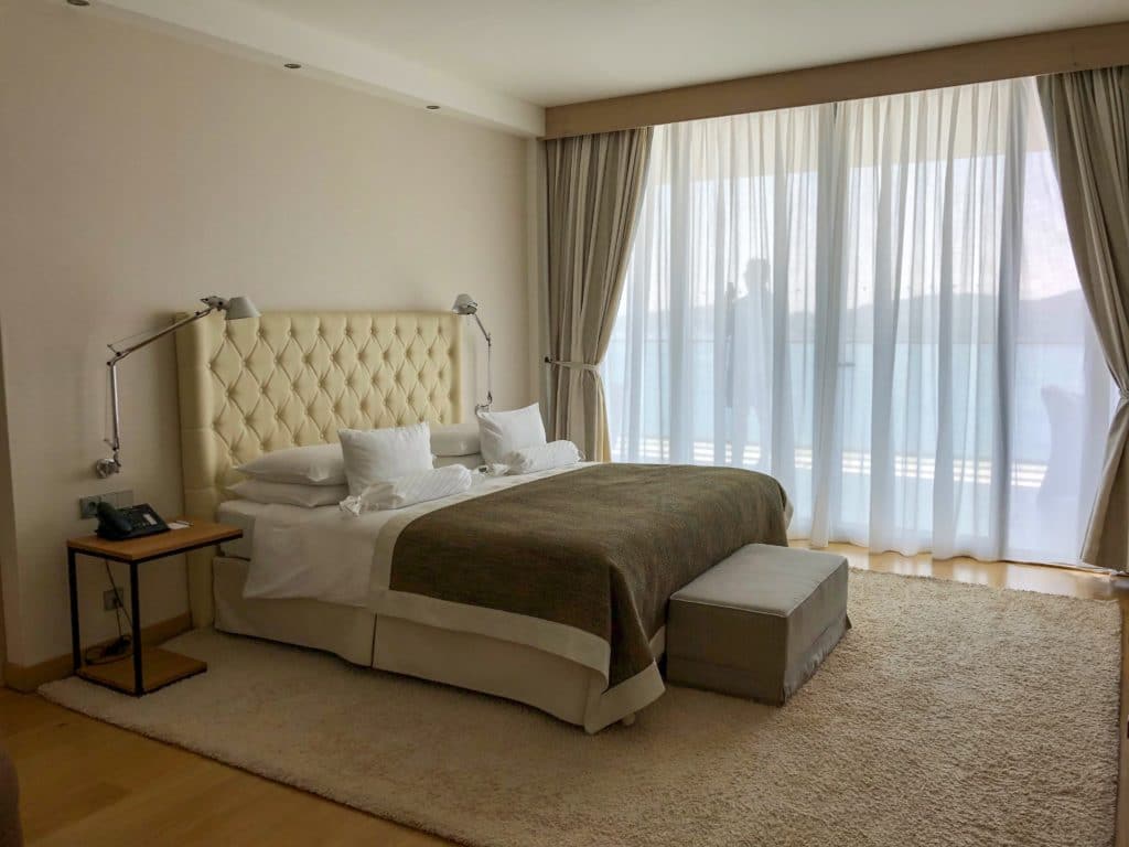 Quarto com cama, cabeceira e tapete do hotel Sun gardens