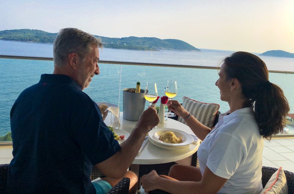 Homem e mulher brindam com vinho branco na varanda da suíte do melhor hotel de Dubrovnik