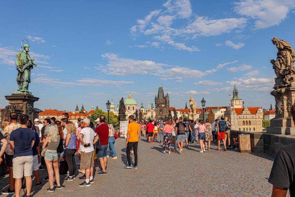 Ponte Carlos IV com pessoas fotografando estátuas em Praga