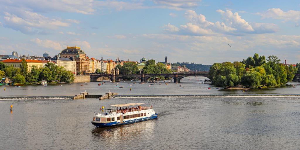 Barco com ponte ao fundo em Praga perto da Ponte Carlos