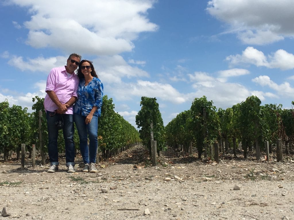 Casal em frente a plantação de parreiras