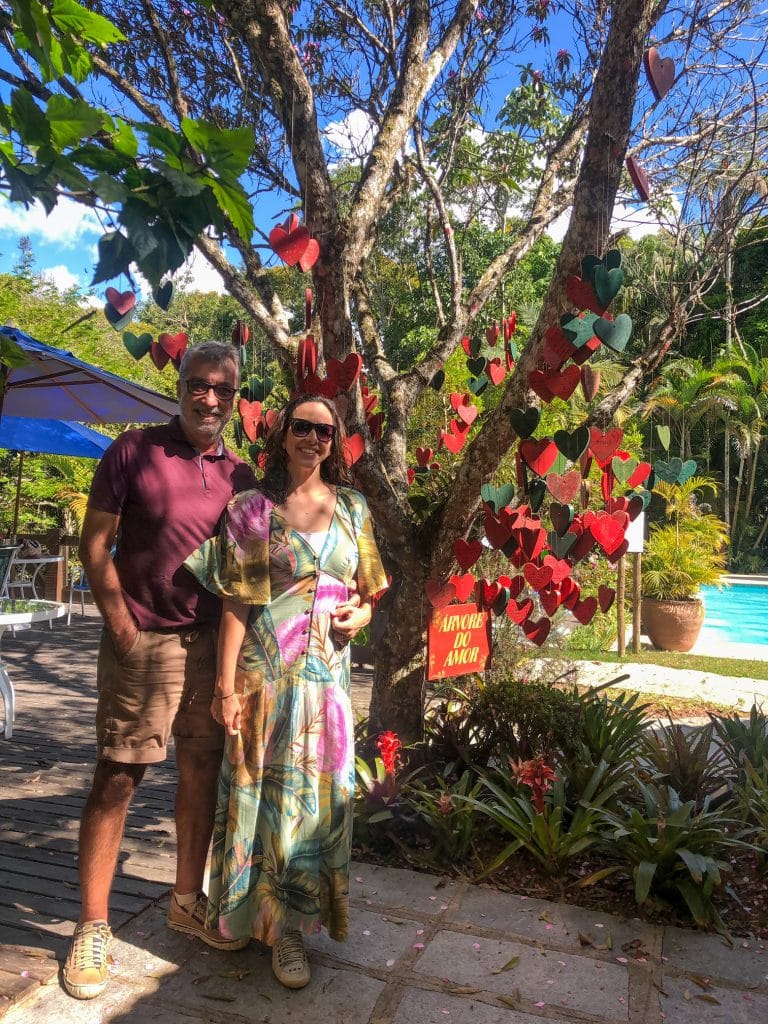 Casal perto da árvore no hotel com piscina ao fundo do hotel com hidro e piscina em Teresópolis