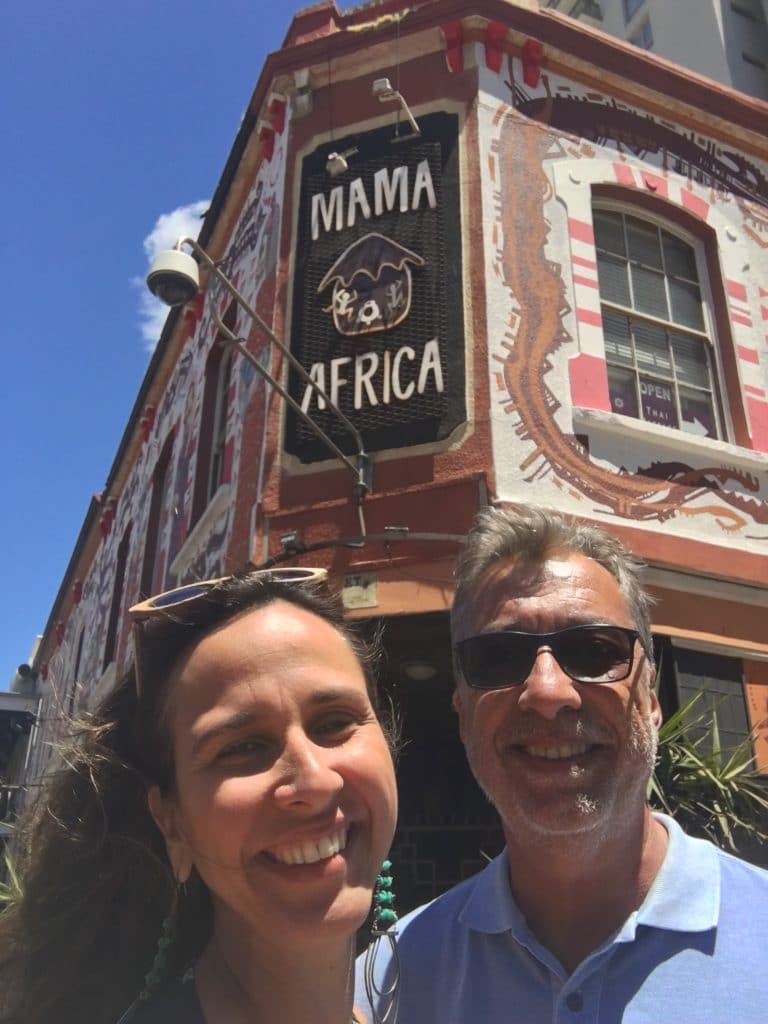 casal sorrindo em frente ao restaurante Mamma África em Cape Town