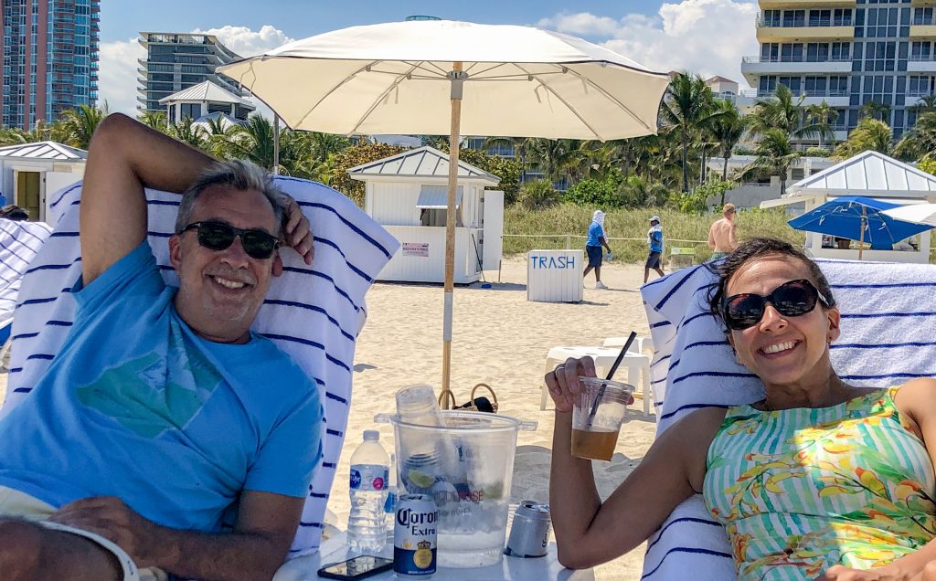 Casal na praia bebendo uns drinques em Miami Beach