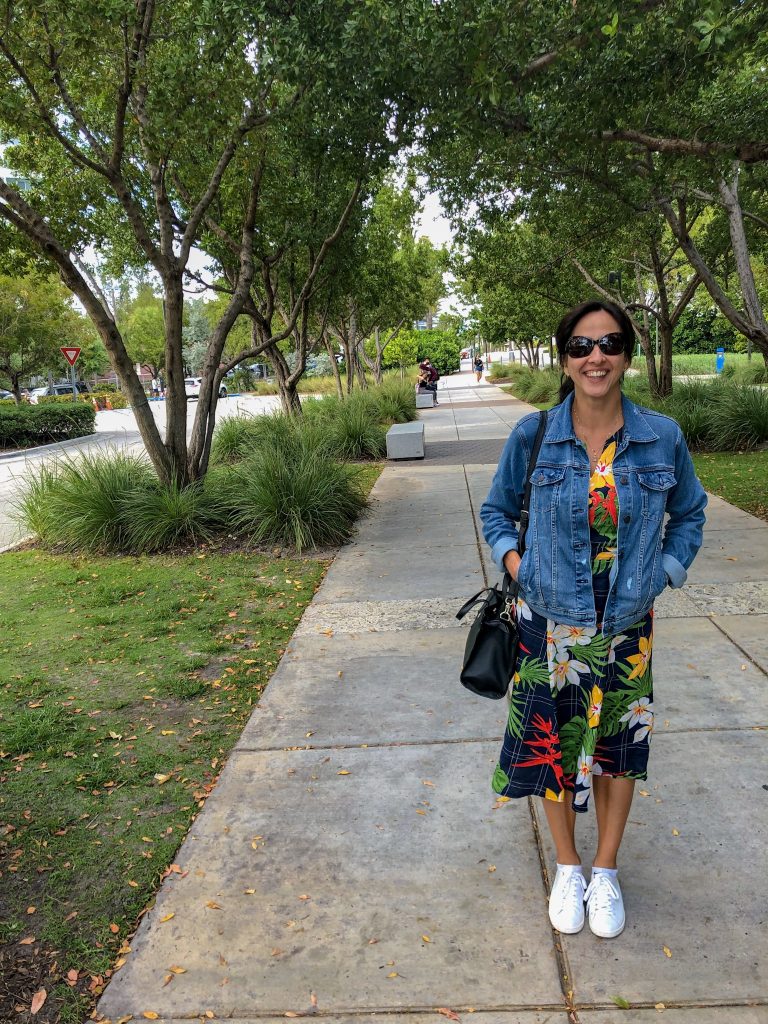 Mulher com vestido de flores e tênis branco em Miami