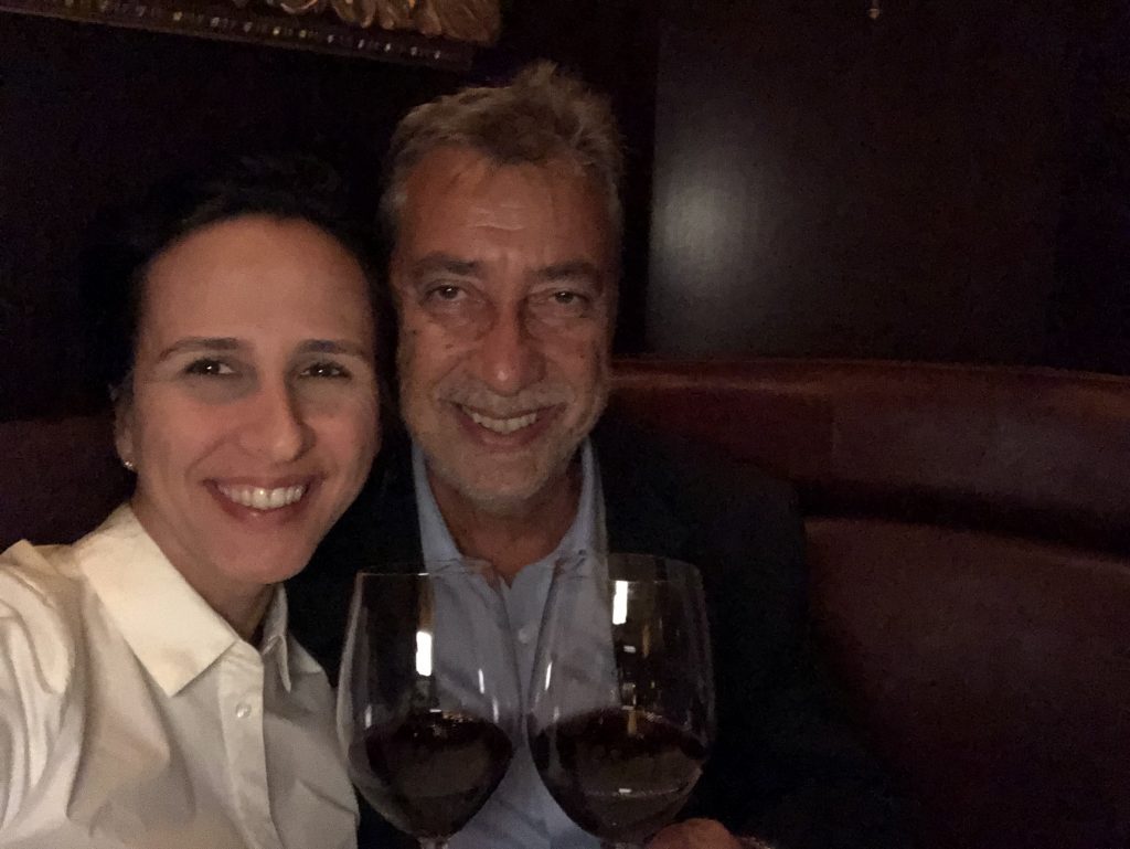 Casal brindando com vinho e sorrindo em restaurante em Miami