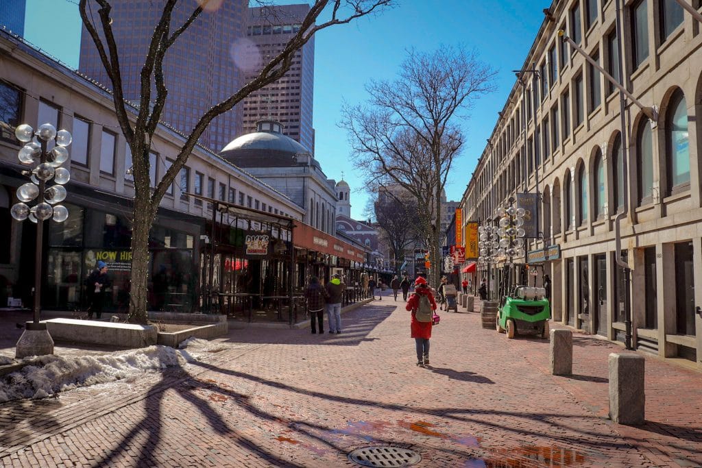 Rua com lojas e pessoas caminhando em Boston