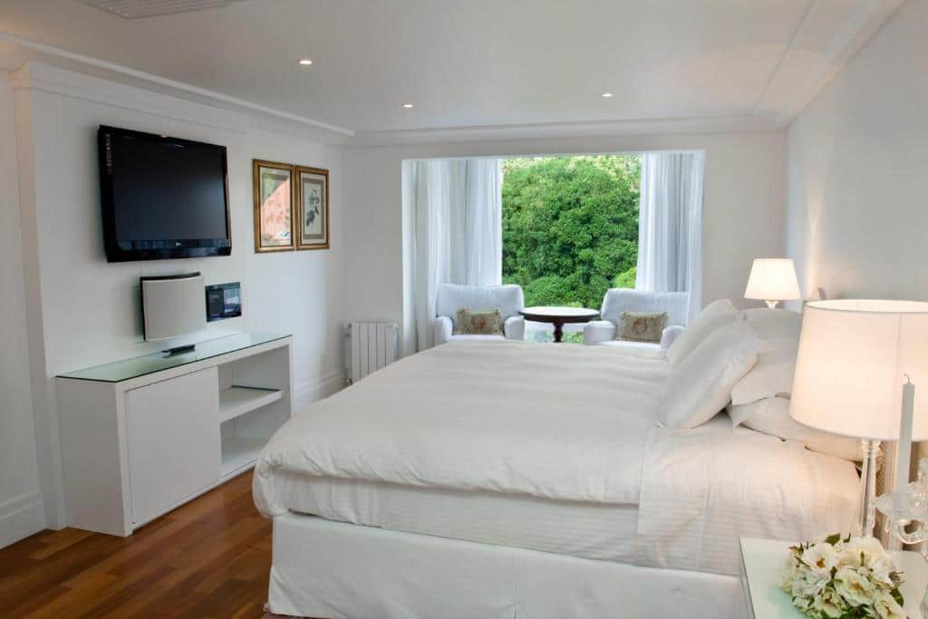 Quarto com cama e poltronas