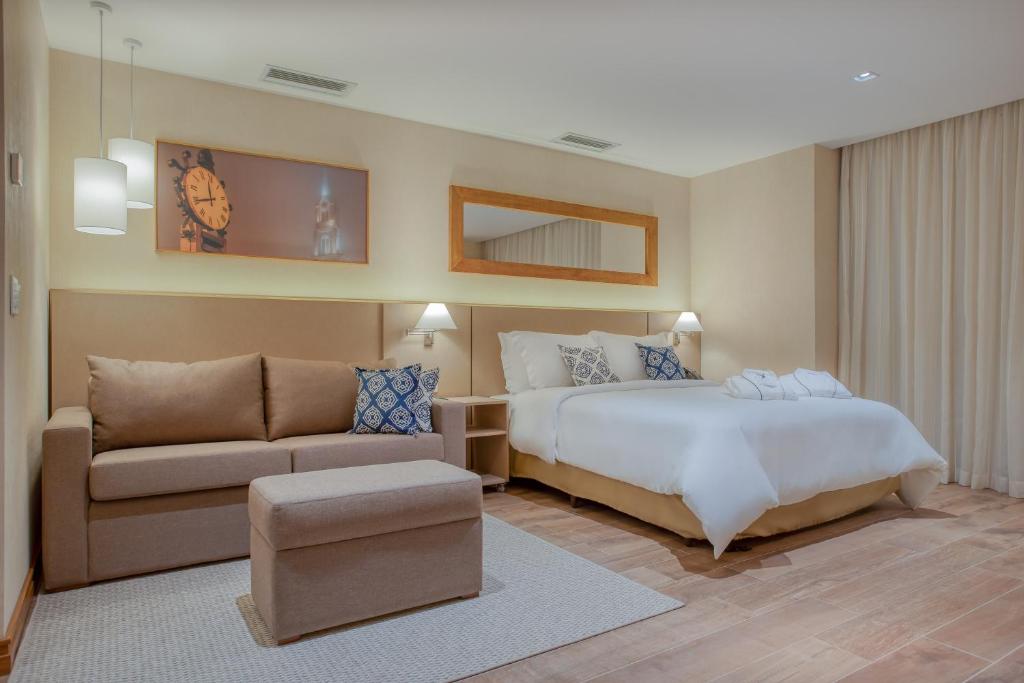 Quarto de hotel em Gramado com cama e sofá.