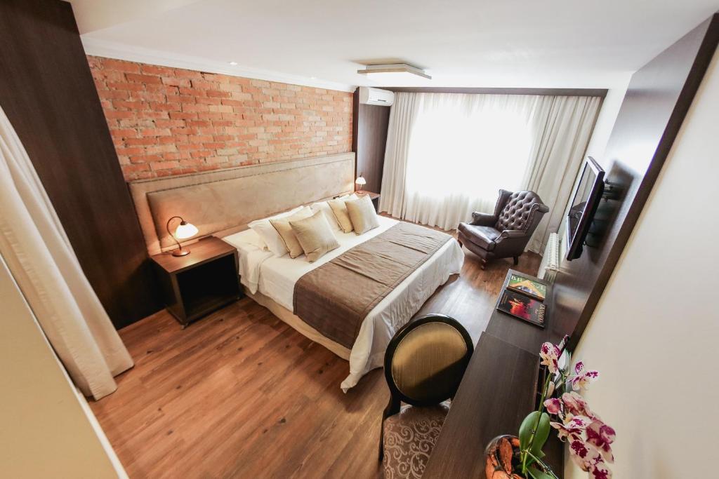 Quarto de hotel em Gramado com cama e poltrona