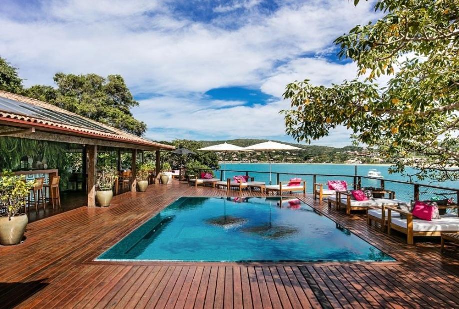 Piscina com vista para o mar e algumas espreguiçadeiras em Búzios