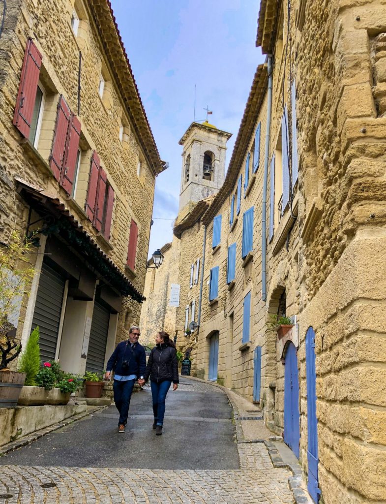Casal caminhando em rua de Chateauneuf-du-pape, na França, em viagem sabática