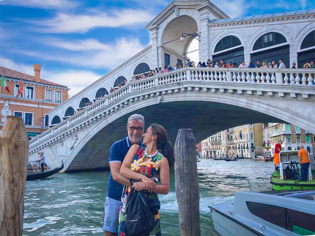 Casal se abraçando em frente a ponte de Veneza