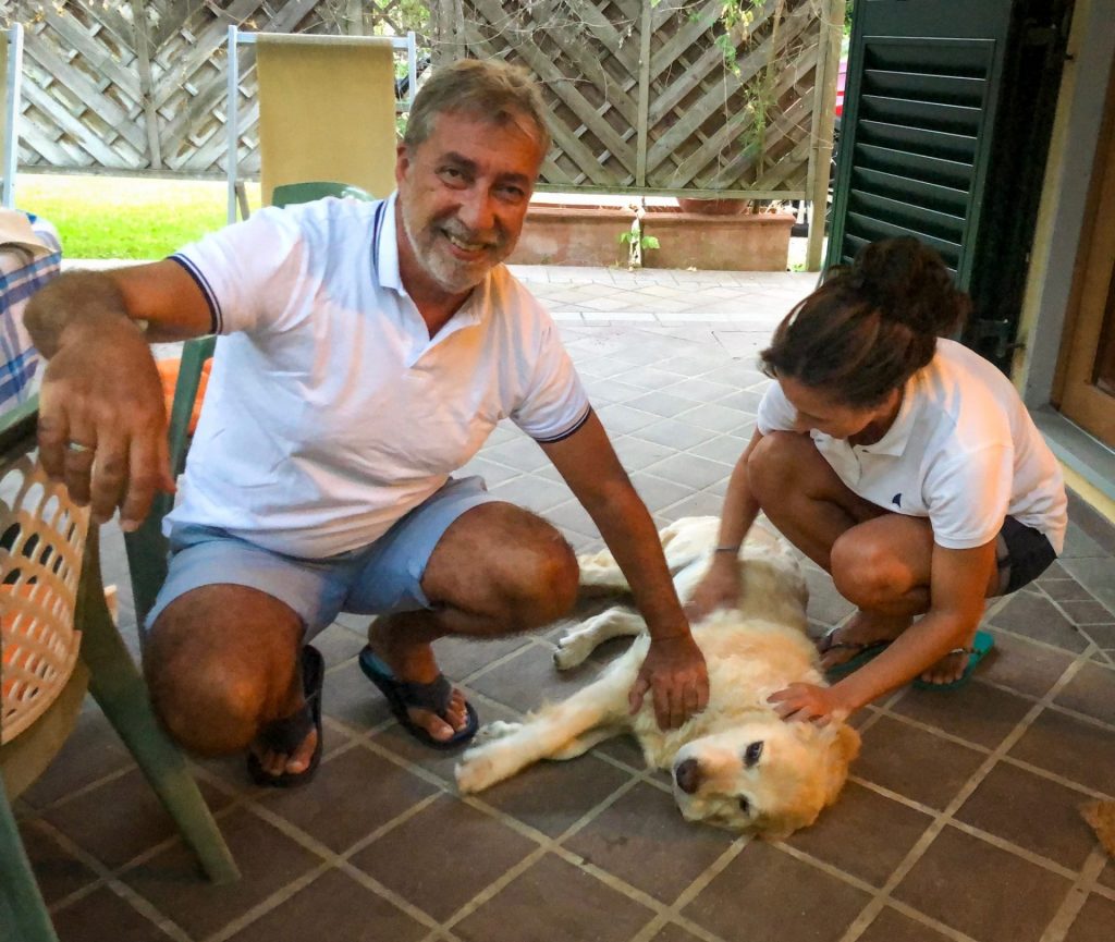 casal fazendo carinho em cachorro deitado no chão em viagem sabática