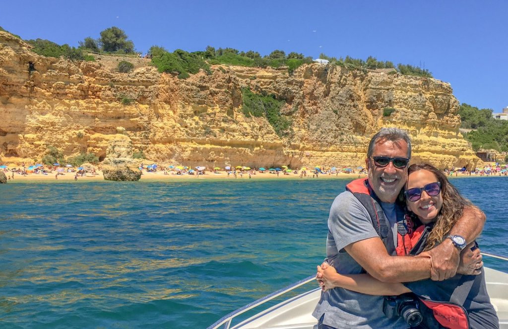 Casal em barco se abraçando em frente a praia da Marinha no Algarve