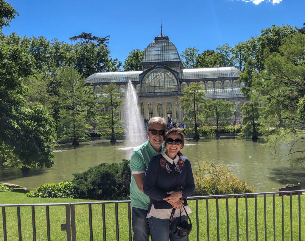 Casal em frente ao palácio de cristal em Madri