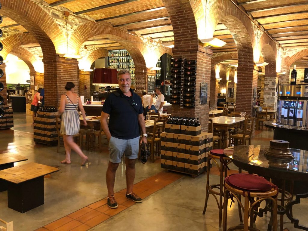 Homem sorrindo dentro de loja de vinhos na rota do vinho Chianti